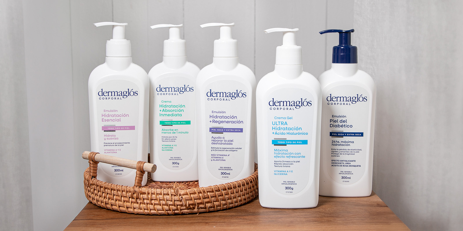 5 botellas de crema corporal Dermaglós con pico dosificador en un entorno de baño luminoso, elegante y minimalista.