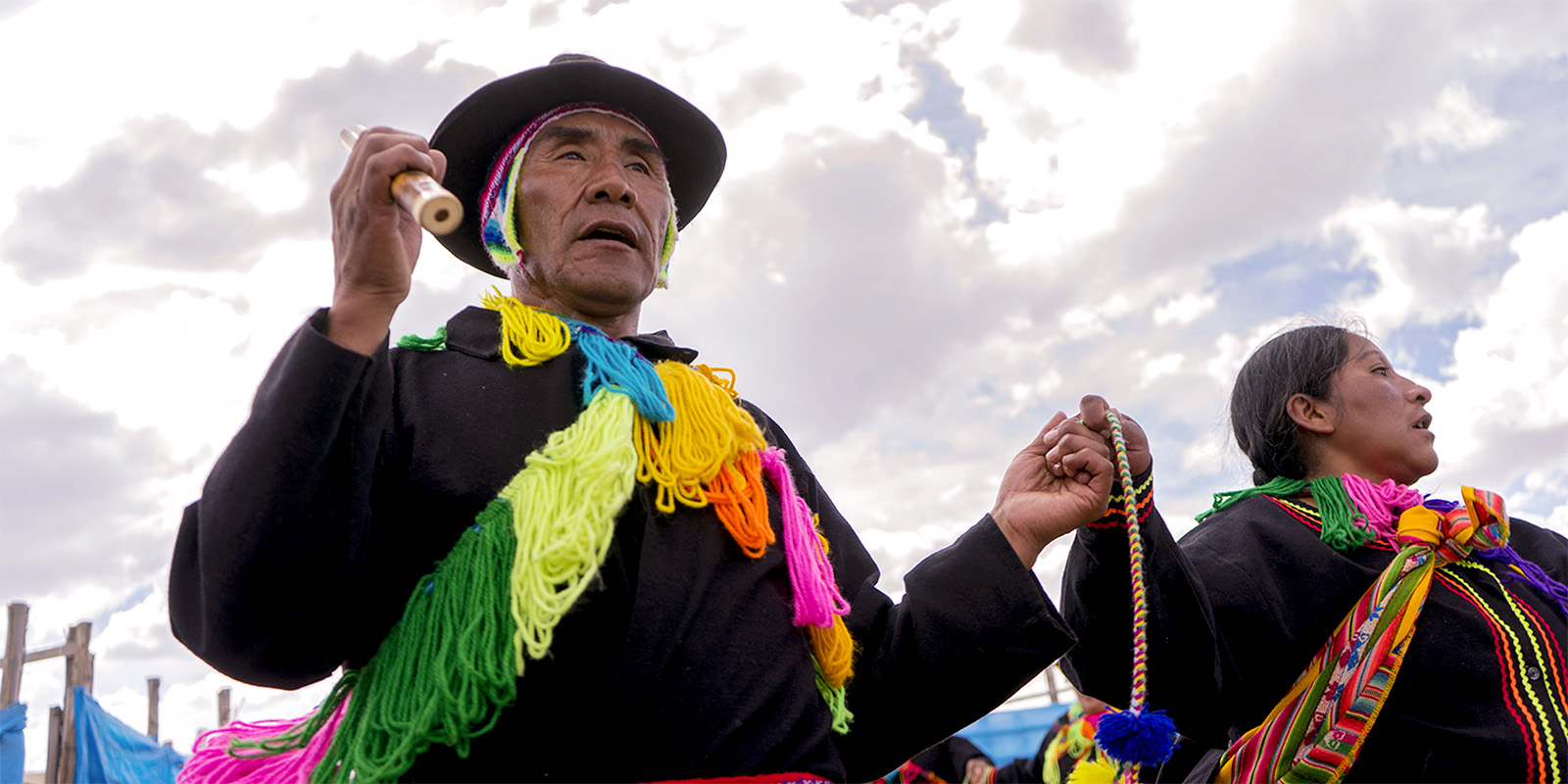 Personas nativas de Perú en una danza típica con trajes tradicionales coloridos.