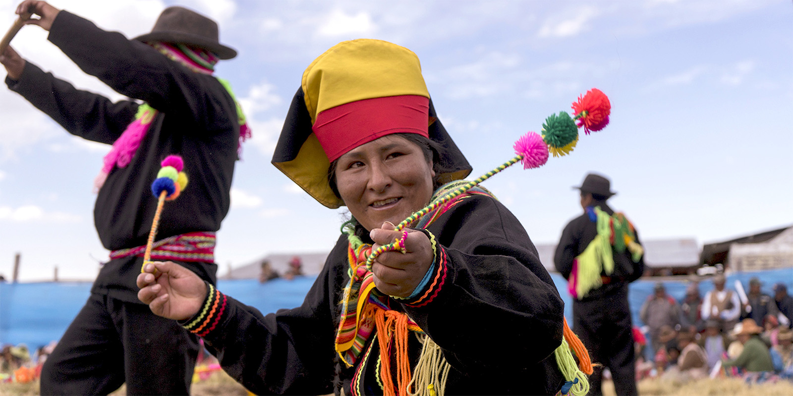 Personas nativas de Perú en una danza típica con trajes tradicionales coloridos.