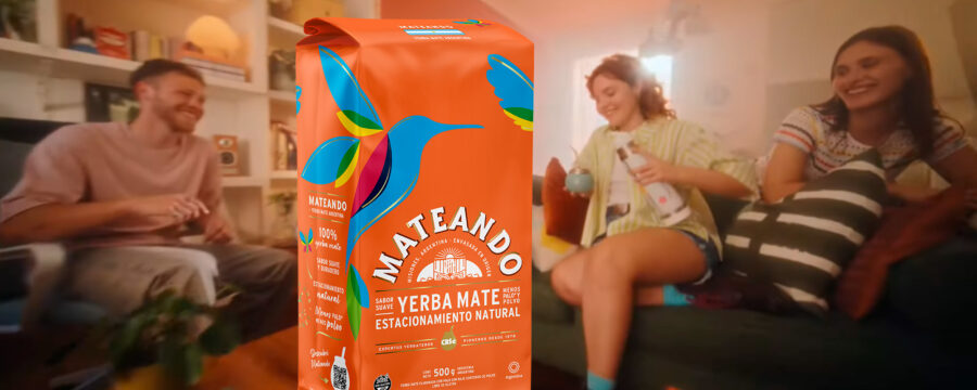 Grupo de jóvenes riendo y compartiendo un mate en una sala de estar, con un paquete de yerba Mateando en primer plano, destacando su diseño colorido y natural. Diseño de packaging por Tridimage.